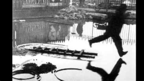 henri cartier bresson man jumping over puddle