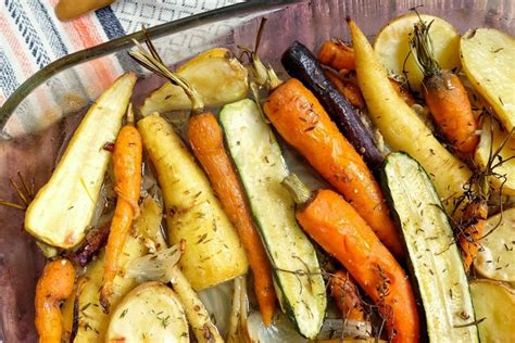 Un plat de légumes rôtis colorés, notamment des carottes, des courgettes et des poivrons