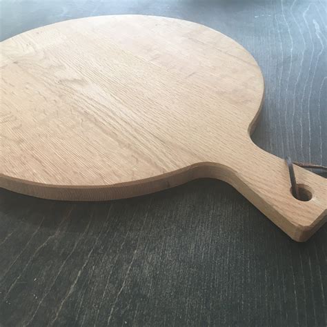 large round wooden cutting board with handle