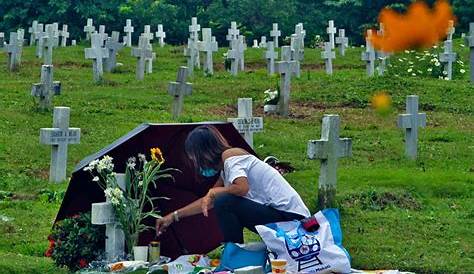 A relative pays her respects to a departed loved one at the Libingan ng