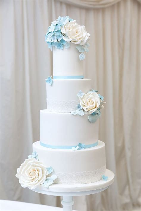 Two tier marble dusty light blue wedding cake with gold foil anenome