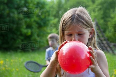 little girl blowing up balloon