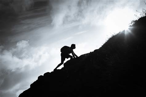 man climbing up a mountain