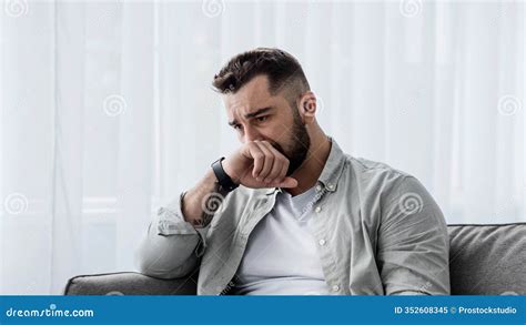 man crying on a sofa