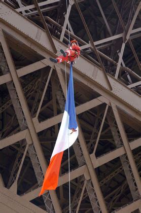 man hanging from eiffel tower