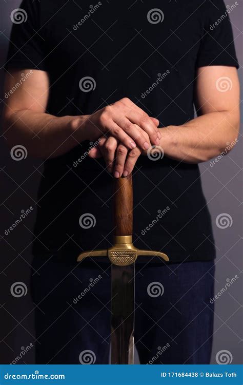 man holding sword into ground