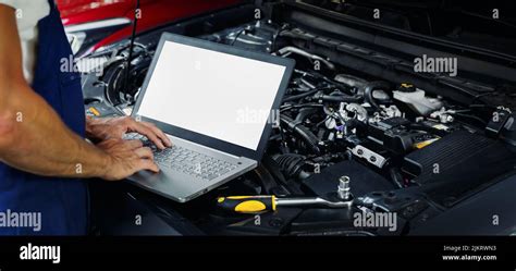 Mechanic Using Computer to Diagnose Car Engine