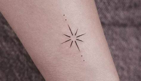 Minimalist star tattoo on the left inner arm. 