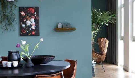 Mur bleu dans le salon avec canapé en bois et bolia du