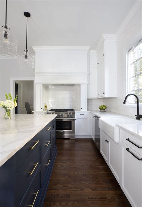 Navy blue island in a perfectly white painted kitchen. White subway