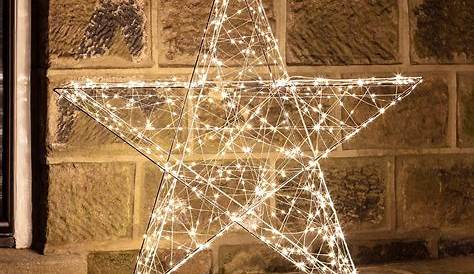 a large white lighted christmas star in the dark