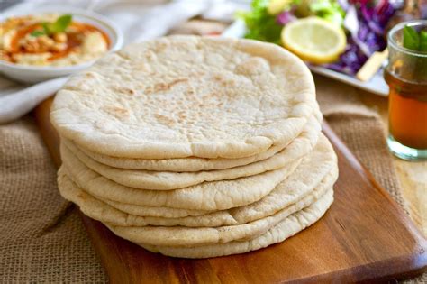 Close-up of freshly baked pita breads arranged in a round shape and dusted with flour