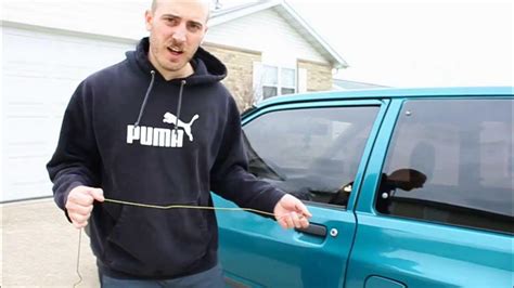 Image of a person opening a car door after unlocking it with a coat hanger