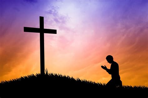 person praying at cross