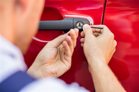 Image of a person unlocking a car door with a screwdriver