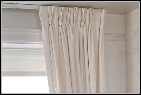 triple pinch pleat curtains on a track under a pelmet board around a