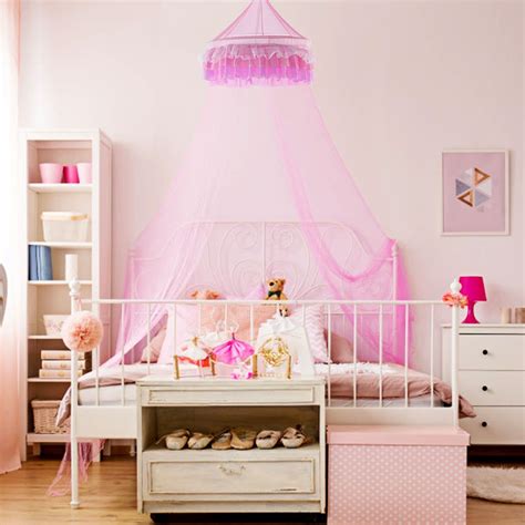 Pink and white canopy bed with a princess theme in a girl's bedroom