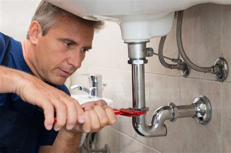 plumber fixing a drain pipe
