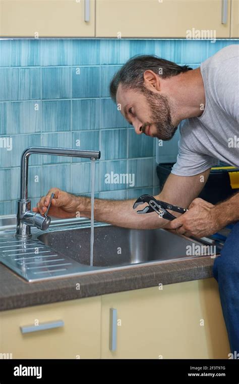 plumber fixing leaky faucet
