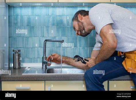 professional plumber examining faucet