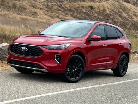 A vibrant red Ford Escape parked on a scenic road, showcasing its stylish design and adventurous spirit.