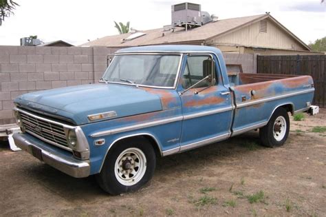 A selection of various second hand Ford trucks parked in a dealership lot, showcasing different models and years.