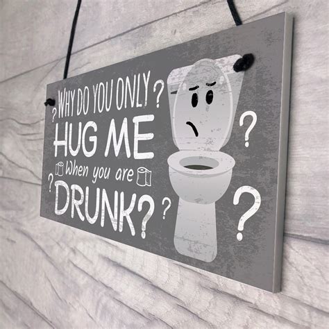 signs hanging on wall over toilet