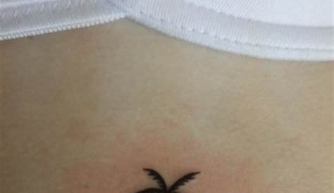 Small palm tree tattoo on the left wrist.