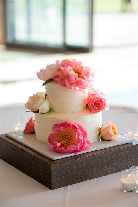 Simple and elegant white wedding cake with white flowers and accent