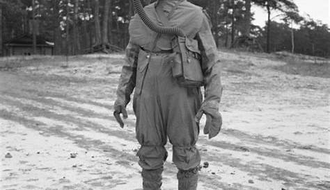 Portrait Of Young Soldier Wearing Gas Mask Against A Cloudy Sky