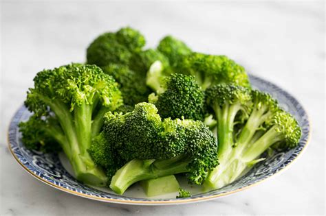Steamed broccoli florets arranged in a circle with a dipping sauce in the center
