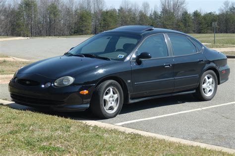 Side profile of a 1998 Ford Taurus, showcasing its aerodynamic design