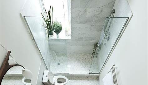 a white bath tub sitting under a window in a bathroom