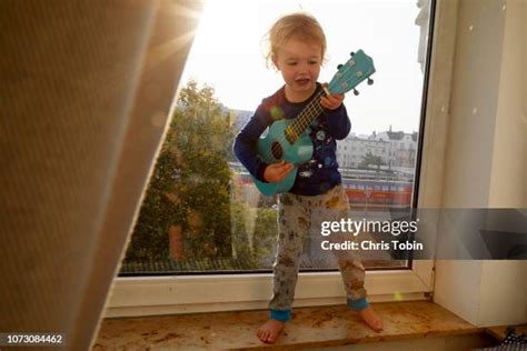 Free stock photo of Toddler boy singing while playing ukulele