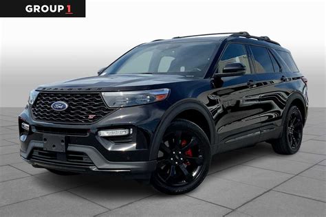 A black used Ford Explorer ST parked on a scenic road, showcasing its sporty design
