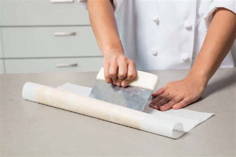 Using a bench scraper to smooth frosting on a cake.