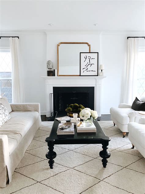 Warm white walls with dark wood ceiling beams; gallery wall; and cozy