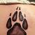 wolf in paw print tattoo
