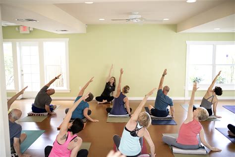 A group of people practicing yoga in a spacious studio, representing community and holistic well-being
